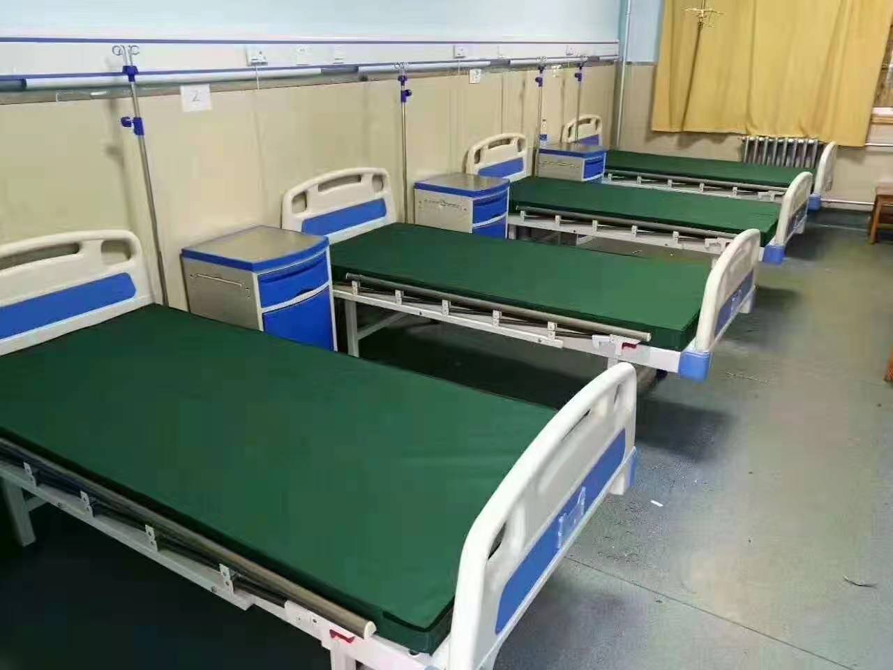 Hospital patient bed positioned in a wide room demonstrating door clearance and bed maneuvering space requirements