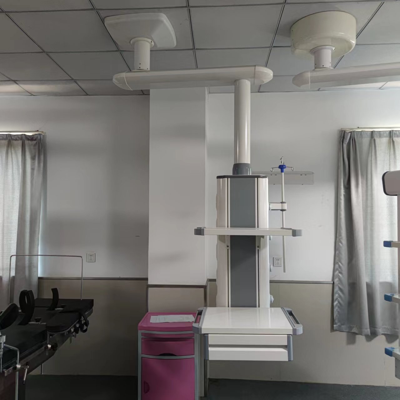 Single-arm surgical pendant showing arm joint, column, and cable routing requiring weekly and monthly cleaning zones