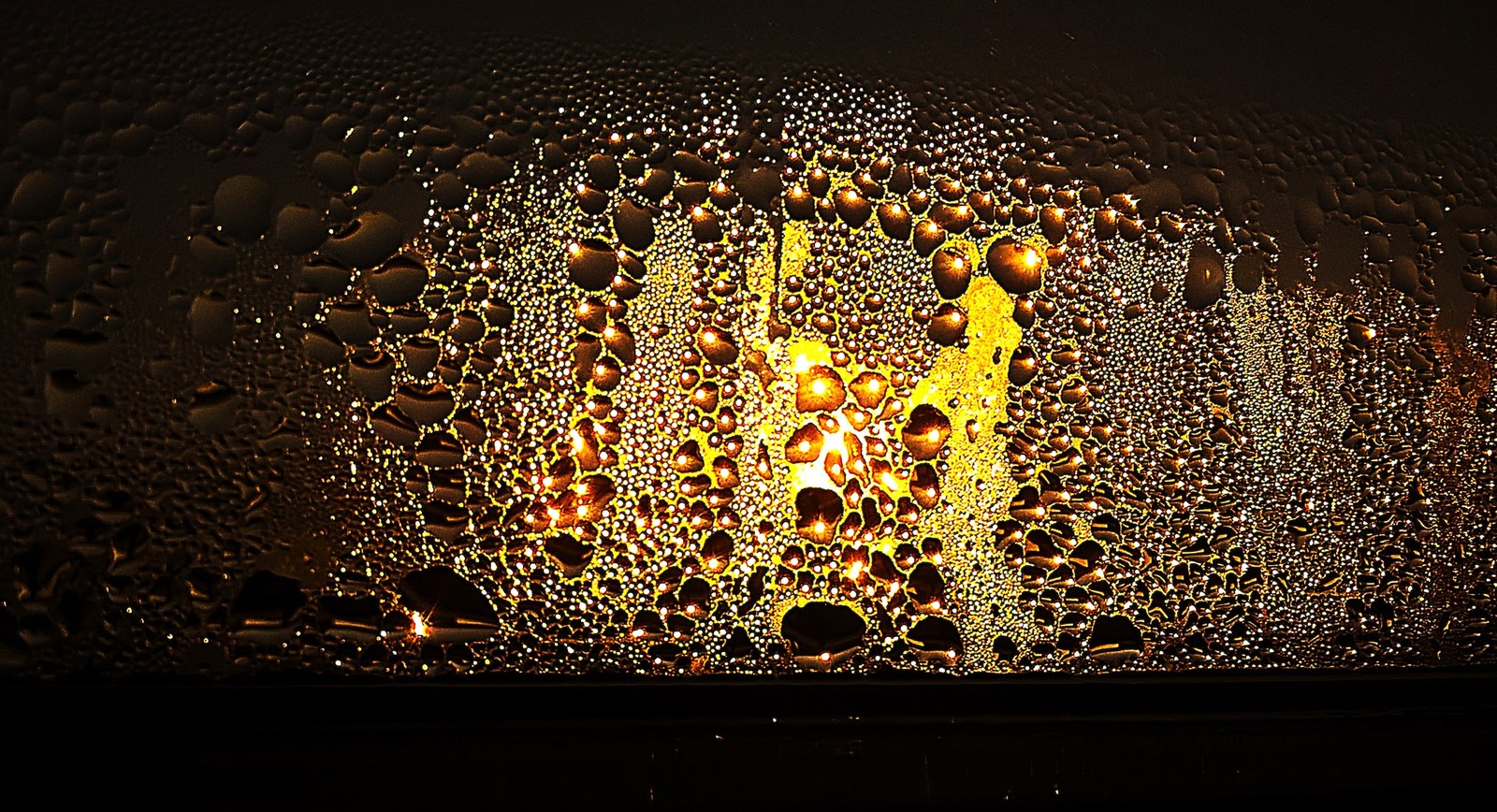 Condensation beading on window glass, the same moisture that gathers inside an export crate stored unopened through a wet season